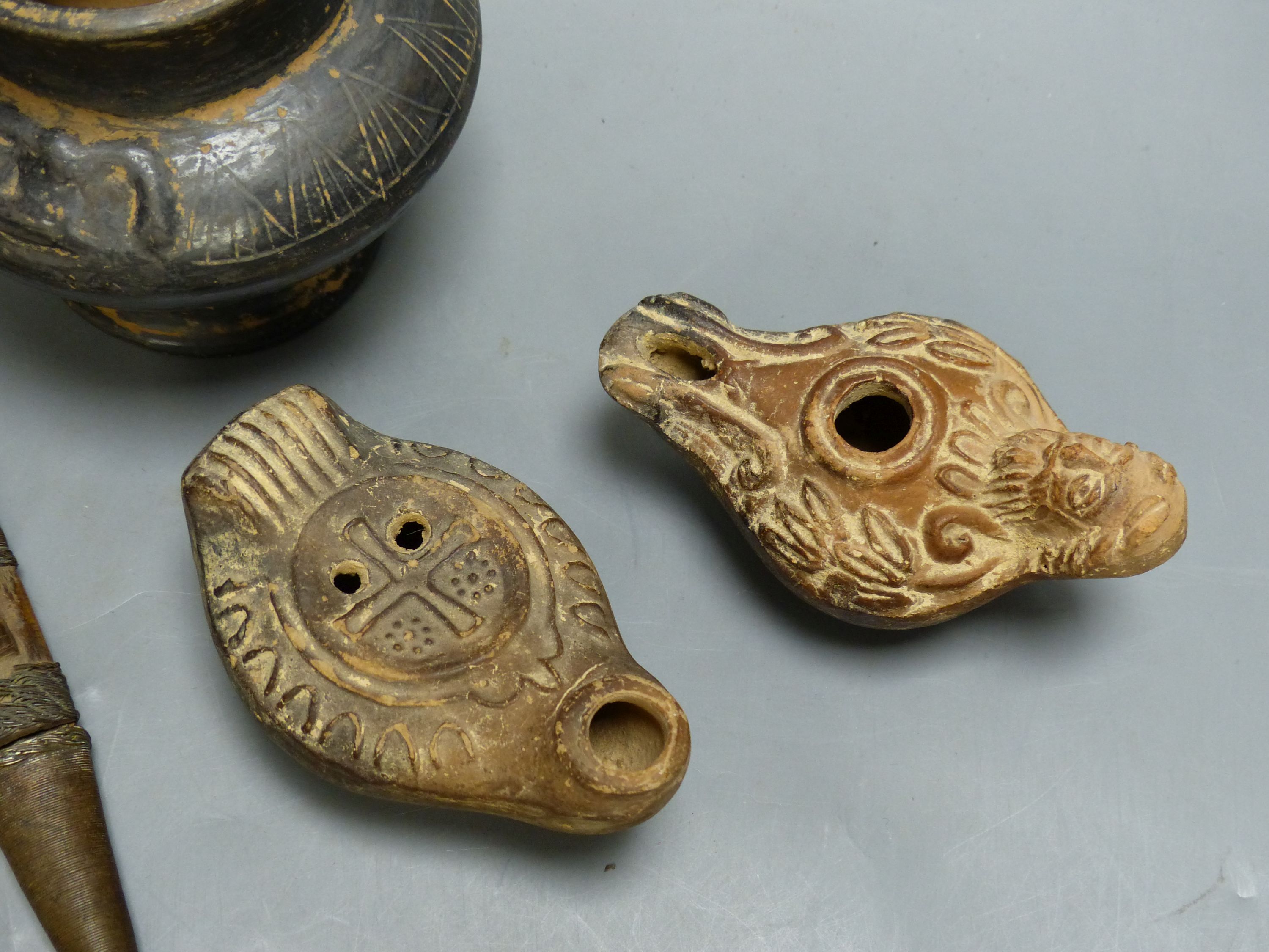 A group of antiquities, three oil lamps, a vase and a figure, etc.